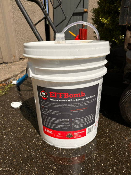 a pail of effbomb with a pressure washer's downstream injector tube inside of it while being used on a post construction cleaning job